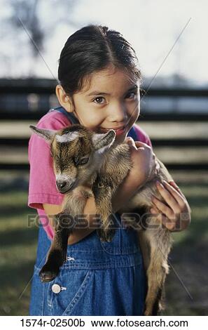 Portrait of a girl holding a kid goat in her arms View Large Photo Image Stock Image - Portrait of a girl holding a kid goat in her arms. Fotosearch