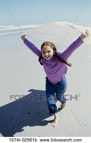 Stock Image - Portrait of a girl running on the beach. Fotosearch