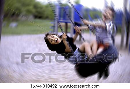 Stock Image - Portrait of a girl sitting on a swing. Fotosearch