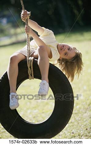Portrait of a girl sitting on a tire swing View Large Photo Image Stock Image - Portrait of a girl sitting on a tire swing. Fotosearch