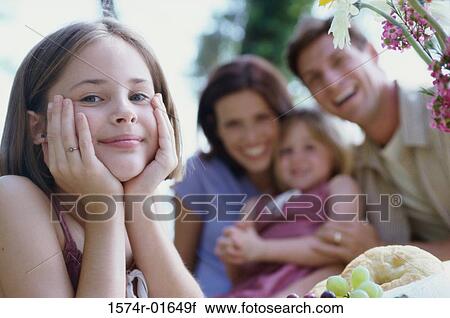 Portrait of a girl with her family in the background View Large Photo Image Stock Image - Portrait of a girl with her family in the background. Fotosearch