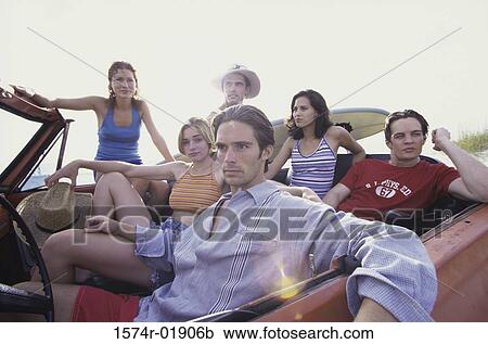 Stock Image - Portrait of a group of young people in a convertible car. Fotosearch
