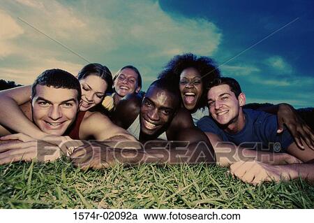Portrait of a group of young people lying on grass View Large Photo Image Stock Image - Portrait of a group of young people lying on grass. Fotosearch