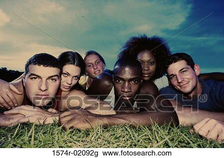 Portrait of a group of young people lying on grass View Large Photo Image Stock Image - Portrait of a group of young people lying on grass. Fotosearch