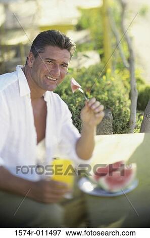 Portrait of a man eating watermelon View Large Photo Image Stock Photo - Portrait of a man eating watermelon. Fotosearch