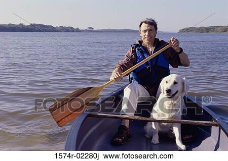 Portrait of a mid adult man sitting in a row boat with his dog View Large Photo Image Stock Image - Portrait of a mid adult man sitting in a row boat with his dog. Fotosearch