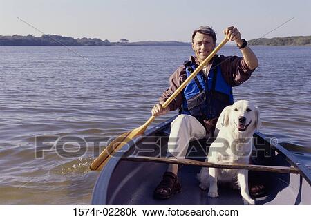 Portrait of a mid adult man sitting in a row boat with his dog View Large Photo Image Stock Image - Portrait of a mid adult man sitting in a row boat with his dog. Fotosearch