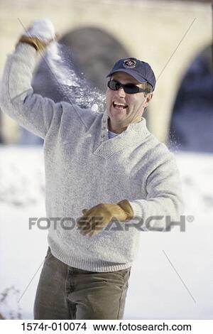 Portrait of a mid adult man throwing snow View Large Photo Image Picture - Portrait of a mid adult man throwing snow. Fotosearch