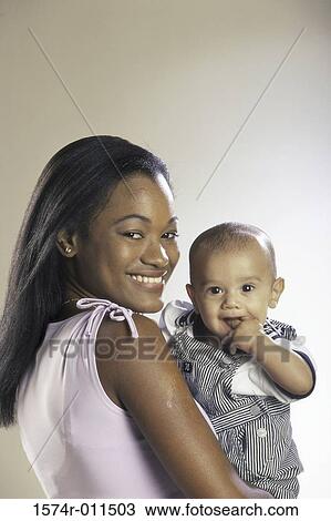 Stock Image - Portrait of a mother holding her baby boy. Fotosearch