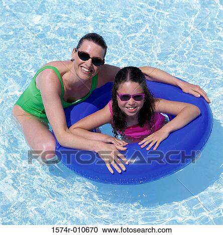 Stock Image - Portrait of a mother with her daughter in a swimming pool. Fotosearch