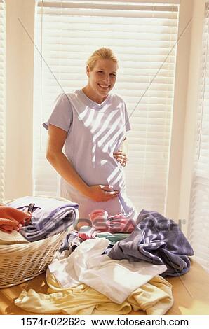 Portrait of a pregnant woman touching her abdomen View Large Photo Image Stock Image - Portrait of a pregnant woman touching her abdomen. Fotosearch