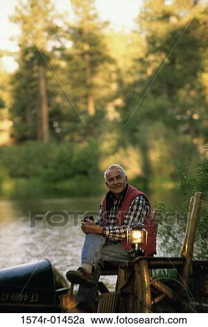 Portrait of a senior man sitting on a chair beside a lamp View Large Photo Image Stock Image - Portrait of a senior man sitting on a chair beside a lamp. Fotosearch