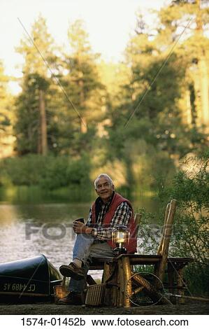 Portrait of a senior man sitting on a chair beside a lamp View Large Photo Image Stock Image - Portrait of a senior man sitting on a chair beside a lamp. Fotosearch