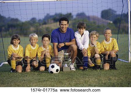 Stock Image - Portrait of a soccer team and coach with a trophy. Fotosearch
