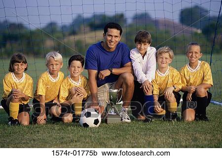 Stock Image - Portrait of a soccer team and coach with a trophy. Fotosearch