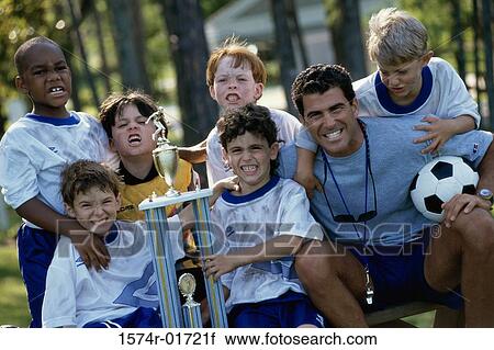 Portrait of a soccer team holding a trophy with their coach View Large Photo Image Stock Image - Portrait of a soccer team holding a trophy with their coach. Fotosearch
