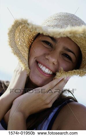Stock Image - Portrait of a teenage girl wearing a straw hat smiling. Fotosearch