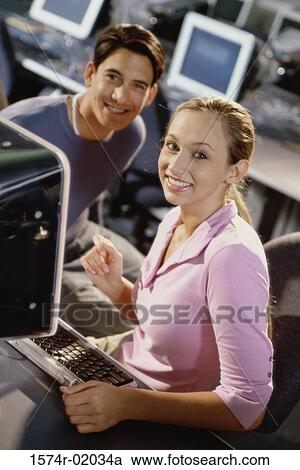 Portrait of a young man and a young woman in front of a computer View Large Photo Image Stock Image - Portrait of a young man and a young woman in front of a computer. Fotosearch