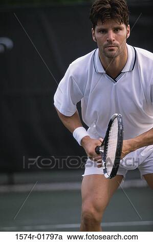 Stock Image - Portrait of a young man playing tennis. Fotosearch