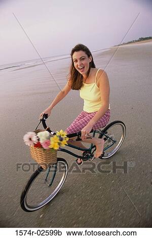 Portrait of a young woman cycling on the beach View Large Photo Image Stock Image - Portrait of a young woman cycling on the beach. Fotosearch