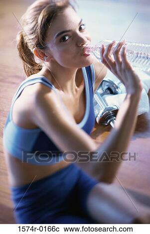 Stock Image - Portrait of a young woman drinking water. Fotosearch