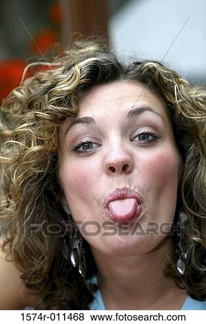 Portrait of a young woman sticking out her tongue View Large Photo Image Stock Photo - Portrait of a young woman sticking out her tongue. Fotosearch