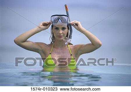 Stock Image - Portrait of a young woman wearing a mask in the water. Fotosearch
