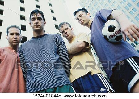 Stock Image - Portrait of four young men with a soccer ball. Fotosearch