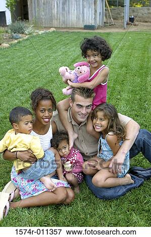 Portrait of parents and their children sitting on a lawn View Large Photo Image Stock Photo - Portrait of parents and their children sitting on a lawn. Fotosearch
