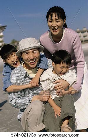 Stock Image - Portrait of parents smiling with their two sons. Fotosearch