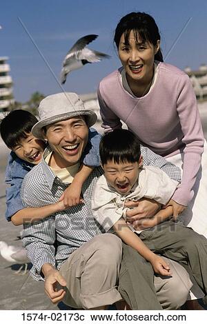 Stock Image - Portrait of parents smiling with their two sons. Fotosearch