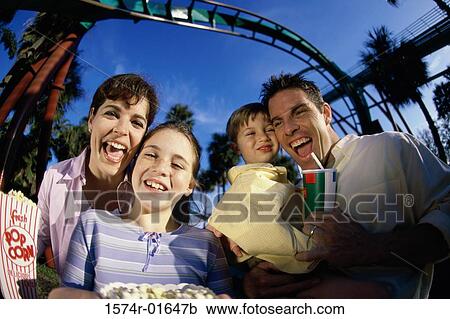 Stock Image - Portrait of parents with their son and daughter in an amusement park. Fotosearch