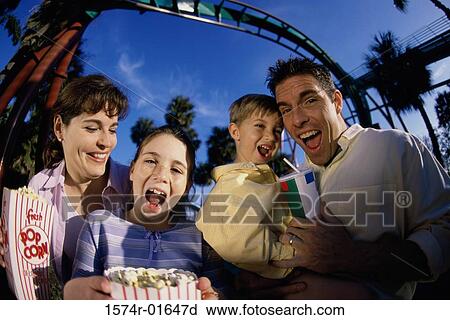 Stock Image - Portrait of parents with their son and daughter in an amusement park. Fotosearch