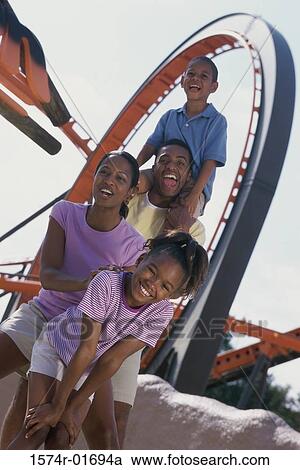 Stock Image - Portrait of parents with their son and daughter at an amusement park. Fotosearch