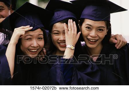 Stock Image - Portrait of three female graduates smiling. Fotosearch