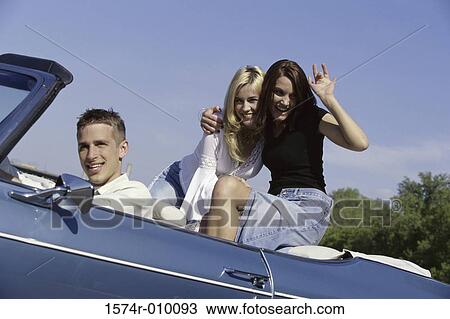 Portrait of three young people sitting in a convertible car View Large Photo Image Stock Image - Portrait of three young people sitting in a convertible car. Fotosearch