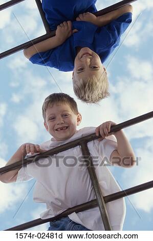 Stock Image - Portrait of two boys playing on monkey bars. Fotosearch