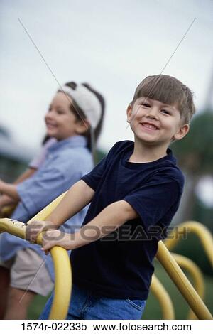 Portrait of two boys standing on a merry-go-round View Large Photo Image Stock Image - Portrait of two boys standing on a merry-go-round. Fotosearch