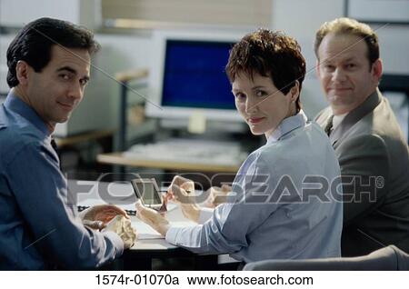 Stock Image - Portrait of two businessmen and a businesswoman smiling. Fotosearch