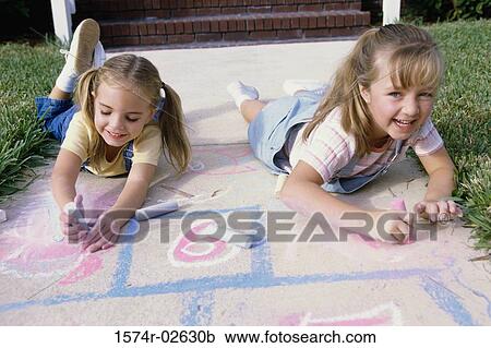 Portrait of two girls drawing on the ground with chalk View Large Photo Image Stock Image - Portrait of two girls drawing on the ground with chalk. Fotosearch