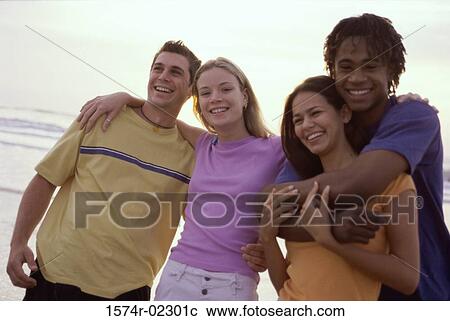 Stock Image - Portrait of two teenage couples on the beach. Fotosearch