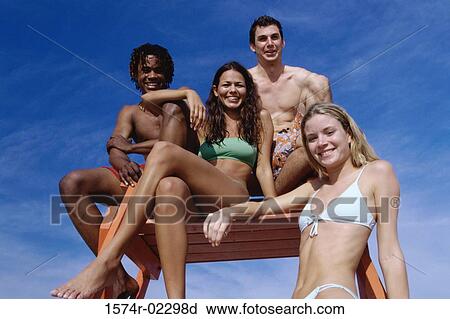 Portrait of two teenage couples sitting on a lifeguard tower View Large Photo Image Stock Image - Portrait of two teenage couples sitting on a lifeguard tower. Fotosearch