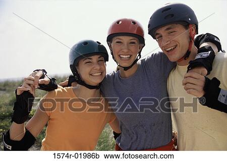 Stock Image - Portrait of two teenage girls and a teenage boy smiling. Fotosearch