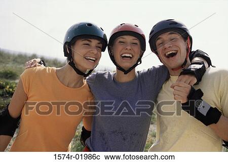 Stock Image - Portrait of two teenage girls and a teenage boy smiling. Fotosearch