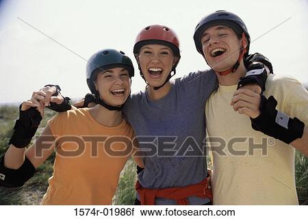 Stock Image - Portrait of two teenage girls and a teenage boy smiling. Fotosearch