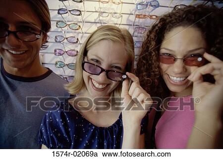 Stock Image - Portrait of two teenage girls and a teenage boy wearing sunglasses. Fotosearch