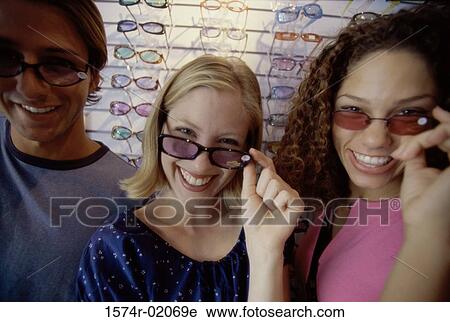 Portrait of two teenage girls and a teenage boy wearing sunglasses View Large Photo Image Stock Image - Portrait of two teenage girls and a teenage boy wearing sunglasses. Fotosearch