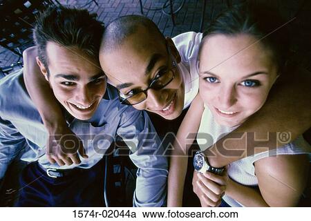 Portrait of two young men and a young woman smiling View Large Photo Image Stock Image - Portrait of two young men and a young woman smiling. Fotosearch