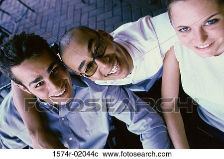 Portrait of two young men and a young woman smiling View Large Photo Image Stock Image - Portrait of two young men and a young woman smiling. Fotosearch