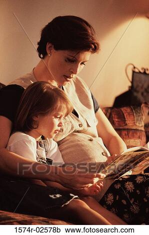 Stock Image - Pregnant woman teaching her daughter. Fotosearch